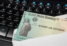 Scott Bessent Has Some Very Good News for Taxpayers U.S. Treasury check partially out of an envelope on a computer keyboard