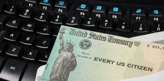 Scott Bessent Has Some Very Good News for Taxpayers U.S. Treasury check partially out of an envelope on a computer keyboard