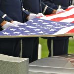 Cruel Scam Targets Grieving Veterans’ Families Honor guard holding an American flag over a casket