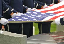 Cruel Scam Targets Grieving Veterans’ Families Honor guard holding an American flag over a casket