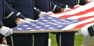 Cruel Scam Targets Grieving Veterans’ Families Honor guard holding an American flag over a casket
