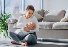 Mother breastfeeding baby on living room floor