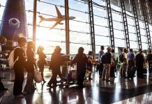 Missile Chaos Cripples Airport – 309 INJURED! Passengers queue inside an airport terminal at sunset