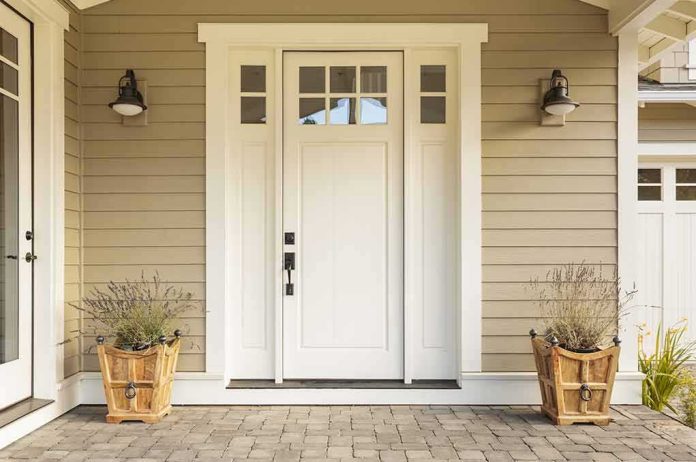 white front door with sidelights and planters