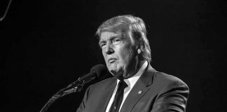 Judge Orders Trump Sit For Deposition in Defamation Lawsuit Donald Trump speaking at a microphone in a black-and-white photo