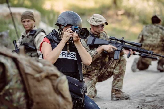 shutterstock_761813914 Teddy Williams photographing near armed soldiers in a field